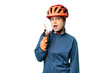 Young cyclist girl over isolated chroma key background thinking an idea pointing the finger up