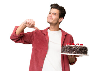 Young caucasian man holding birthday cake over isolated background proud and self-satisfied