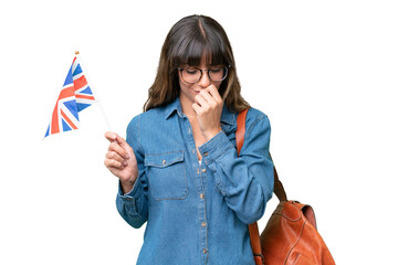 Wall Mural - Young caucasian woman holding an United Kingdom flag over isolated background having doubts