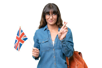 Wall Mural - Young caucasian woman holding an United Kingdom flag over isolated background with fingers crossing and wishing the best