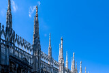 Fototapeta Góry - External view of Milan Cathedral (Duomo di Milano) from the rooftop, Milan, Lombardy, Italy, Europe. Historical marble facade with spires. Gothic architecture features. City travel tourism