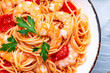 Cooked Italian spaghetti pasta with shrimp and tomato sauce, gray table background, top view