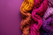 array of hand-knit sweaters in warm autumnal hues on a purple background