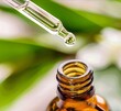 Drop of essential oil dropped into bottle. Oil serum glass bottle and blurry background. Aromatherapy oil