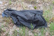 one black winter fabric jacket lies on the ground and green grass on the street