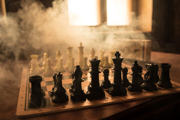 Wall Mural - Chess board game concept of business ideas and competition and strategy ideas concep. Chess figures on a dark background with smoke and fog. Selective focus