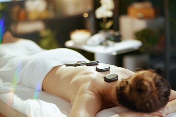 Wall Mural - woman having hot stone massage and laying on massage table