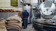 coffee beans factory with a lot of machines and big coffee bags, coffee factory worker