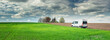 panorama of spring field and white minibus