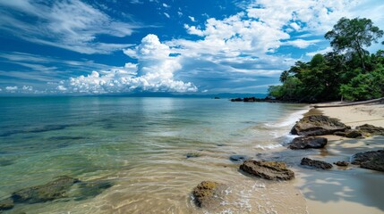 Canvas Print - Scenic beach view with rocky shore, waters, and lush trees