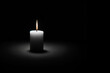 burning white candle on a black background, copy space