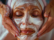 Close up mani di estetista applicando crema viso anti-invecchiamento sul viso della donna cliente per prevenire le rughe in salone spa. Cura della pelle, procedure cosmetiche per la cura del viso e co