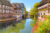 Fototapeta Uliczki - Picturesque half timbered buildings and the Maison des Tanneurs (tanners house) in the Petite France canal zone along the Ill river in the historic city of Strasbourg, in the Alsace region of France.	