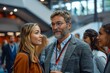 © Pinklife - A middle-aged man with glasses focuses intently during a conversation at a modern conference setting