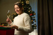 Young smiling beautiful caucasian woman with champagne and gift during Christmas