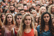 attractive woman looking at camera among crowd of blurred people