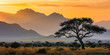 African landscape at sunset with silhouettes of mountains.