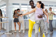© JackF - Emotional adult African American in sportswear performing kizomba paired with attractive woman, demonstrating dance characteristic sensual and connected movements in studio setting..