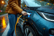 woman recharge EV electric car's battery at parking lot