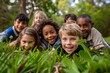 © Asier - Group of happy children lying on the grass and looking at camera.