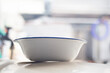 Closeup of a white bowl on a restaurant kitchen table, shallow depth of field