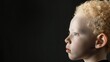 Profile of child with curly blond hair against dark background