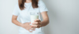 Fototapeta Panele - Lactose intolerance and Milk allergy concept. woman hold Milk glass and having abdominal cramps and pain when drink Cow Milk. Symptom stomach ache, Dairy intolerant, Nausea, Bloating, Gas and Diarrhea