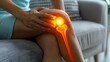 Closeup of a glowing knee on a couch showing joint discomfort. Concept Joint Pain, Knee Health, Physical Discomfort, Medical Condition, Close-up Photography
