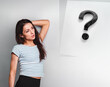 Beautiful young business young casual woman thinking and looking up on question sign on blue studio background on empty copy space. Closeup