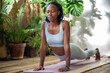 Concentrated african american woman doing yoga. Relaxed black girl with eyes closed stretching on mat achieving spiritual enlightenment, attains awareness. Pilates at home, workout, sports, fitness.