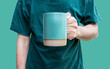 Man hand hold green coffee cup isolated on green background with clipping path