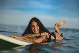 Fototapeta Nowy Jork - Candid lifestyle portrait of a woman on a surfboard