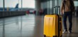 isolate traveler tourist yellow suitcase at floor airport on background window, luggage waiting in departure lounge hall of ​airport lobby terminal, vacation trip concept, empty space mockup, flare