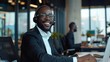 Cheerful black man wearing a headset at a modern office exudes friendliness and professionalism