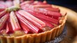 Rhubarb tart close-up, with a focus on the striking pink rhubarb strips and crispy pastry, on a light wood surface. 