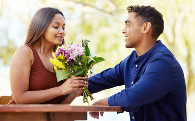 Wall Mural - Man, woman and bouquet at restaurant, outdoor and happy with present, love and romance in summer. Couple, date and smell flowers for gift with smile, care and connection on holiday in countryside