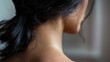 The thick dark hair lining the nape of a neck creating a striking contrast against a pale neckline. .