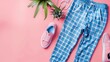 Blue and pink checked pants, pink sneakers and green plant on a pink background. Fashion, still life, flat lay, minimalism, pop art.