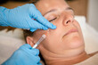 Female patient getting cosmetic facial injection in face at clinic