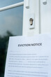 © Shisu_ka - document with the text eviction notice, Civil servant sticks a notice of eviction of the tenants hangs on the door of the house, debt, property, loan, agent, bankruptcy, dispossess, problem.