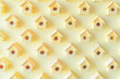 Many yellow birdhouses arranged in a row on a light yellow background flat lay, top view