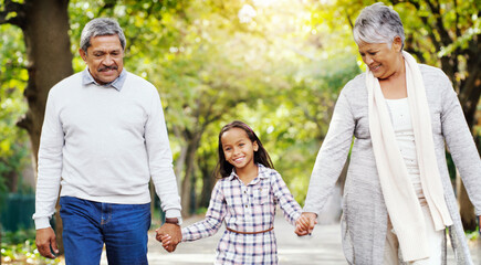 Wall Mural - Park, walk and grandparents holding hands with girl, smile and bonding on outdoor adventure together. Old man, woman and child in nature with love, support and happy family in garden with grandchild.