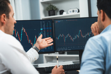 Poster - Stock traders discussing on research market stock database at real time by using two pc screen for comparing with the past of valued and current exchange analyzed business dynamic by minute. Sellable.