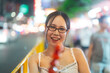 Young adult asian foodie woman eating chinese dessert Tanghulu at china town asia street food