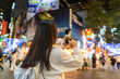 Young female tourist taking a photo of the Ximending shopping street landmark and popular attractions in Taipei, Taiwan