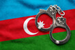 Flag of Azerbaijan and police handcuffs. Crime and offenses in country Concept
