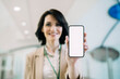 © Westend61 - Smiling businesswoman showing smart phone with blank screen at office