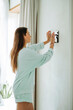 © Westend61 - Woman using tablet PC mounted on wall at home