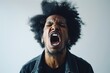 Portrait of a young african american man screaming on a gray background