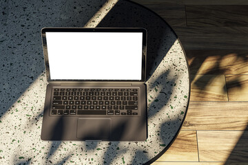 Poster - Top view of modern designer desktop with white mock up laptop on marble desk, sunlight and shadows. Wooden flooring. 3D Rendering.